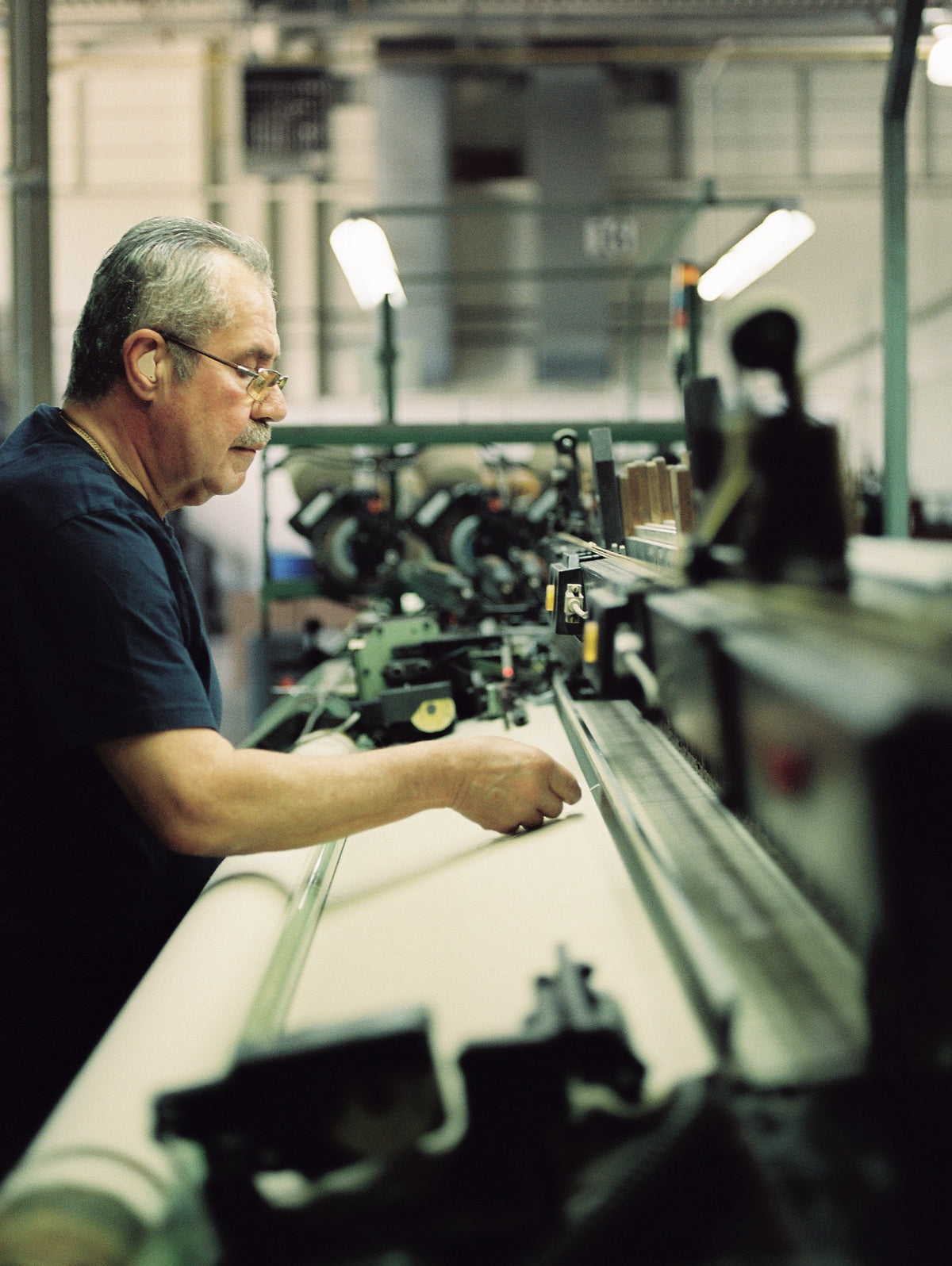 A mill worker at the loom at American Woolen Mills