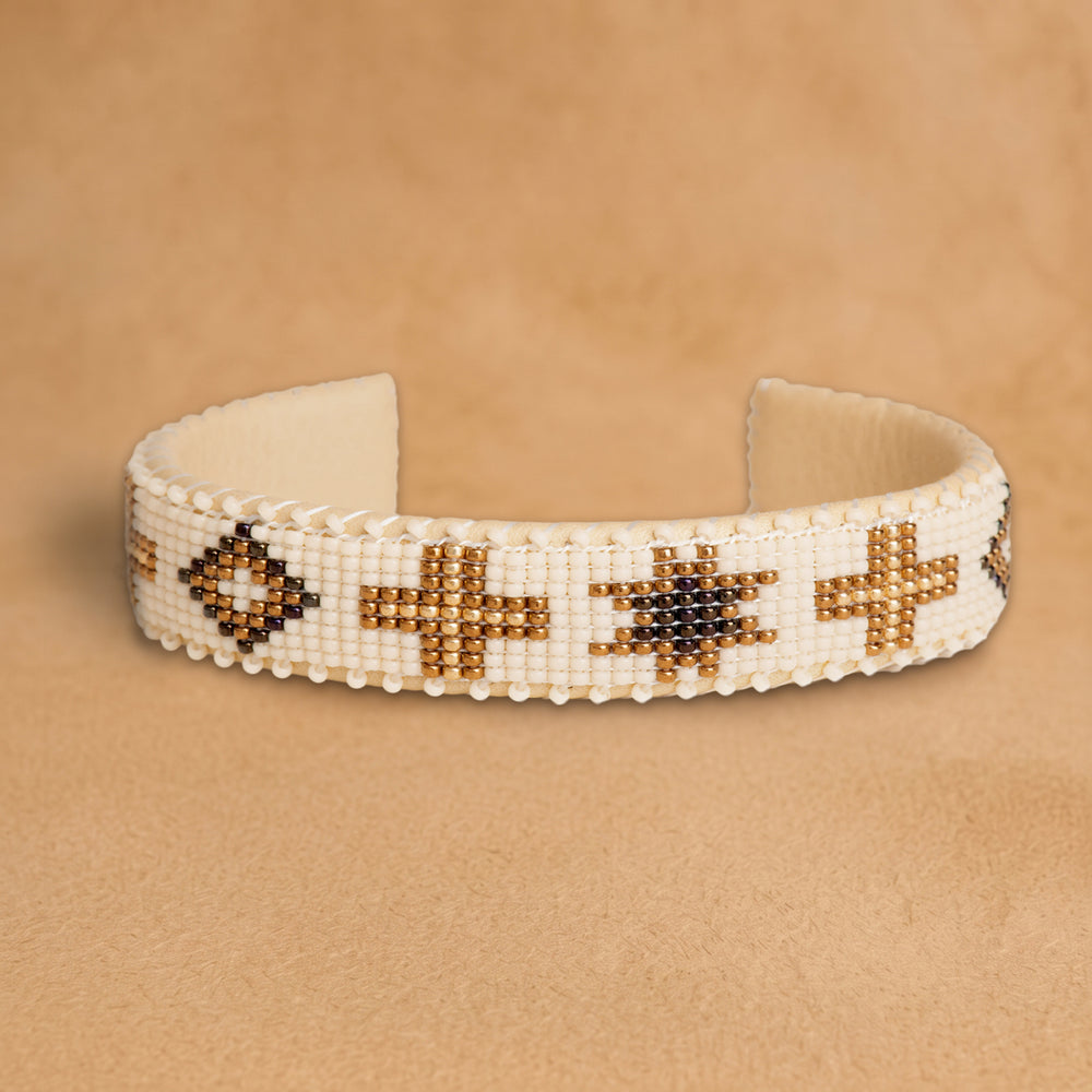 Noelle Small beaded cuff, cream with bronze crosses, diamonds and eight-point stars, handloomed by Navajo artisans in New Mexico