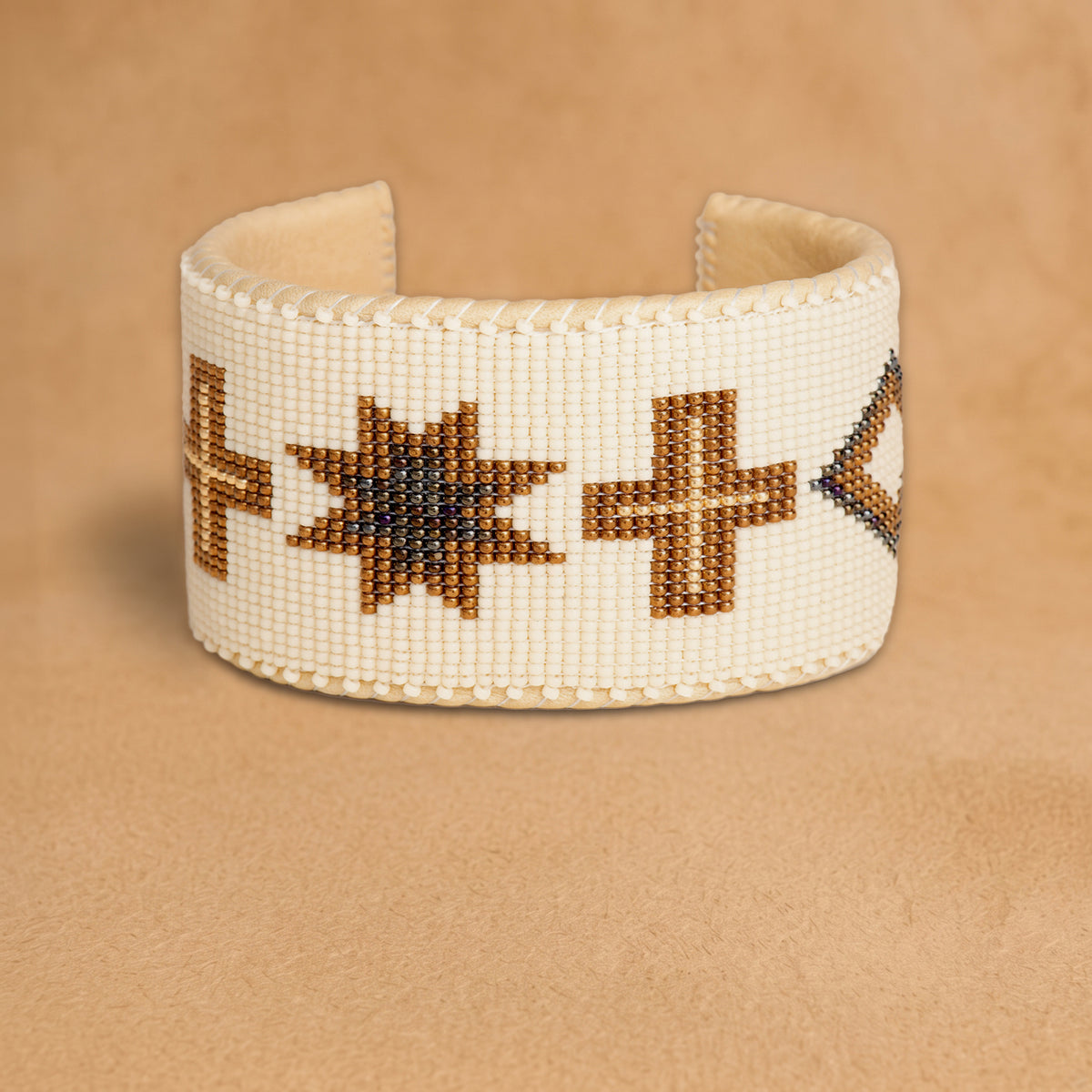 Noelle X Large beaded cuff, cream with bronze crosses, diamonds and eight-point stars, handloomed by Navajo artisans in New Mexico